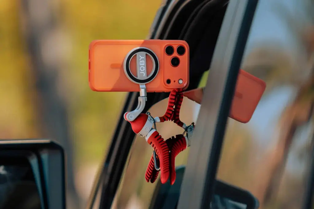 Flexible suction phone mount attached to a car window, holding a smartphone horizontally